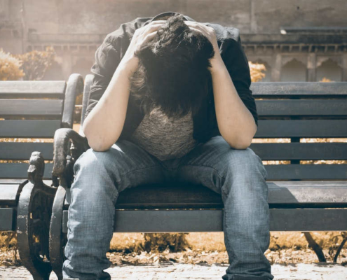 Man stressed on park bench